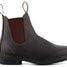 Dark brown leather Chelsea boots with a visible brand logo on a dark background